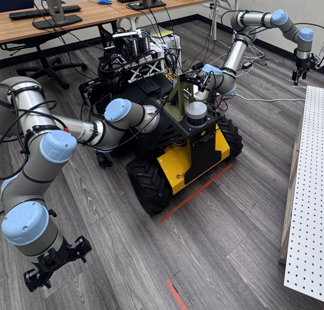 Clearpath Husky with two UR5e arms, grippers, LiDAR and a pan-tilt neck camera